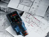 Digital detector placed on architectural blueprints for building layout analysis.