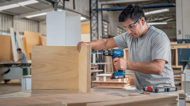 Man drilling wooden boards.