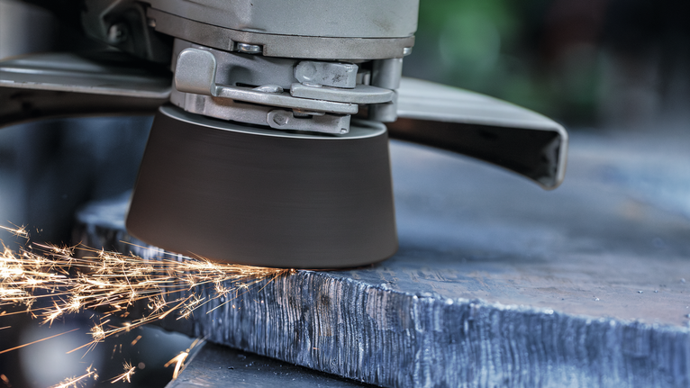 Angle grinder cutting metal, creating sparks.