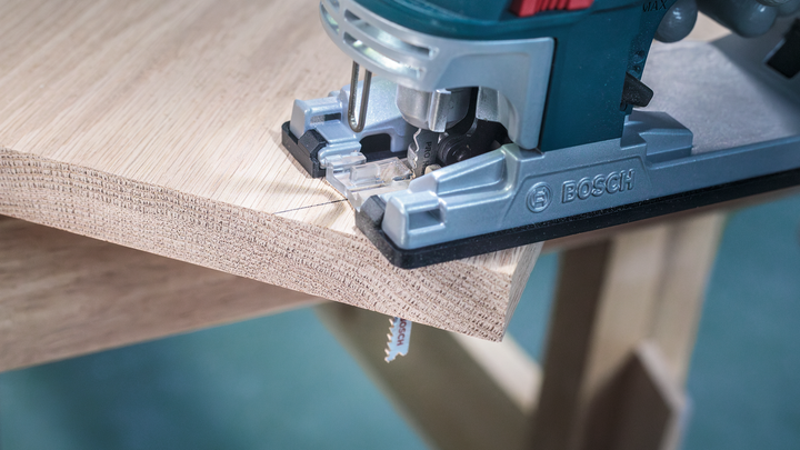 Jigsaw cutting a precise curve into a wooden board.