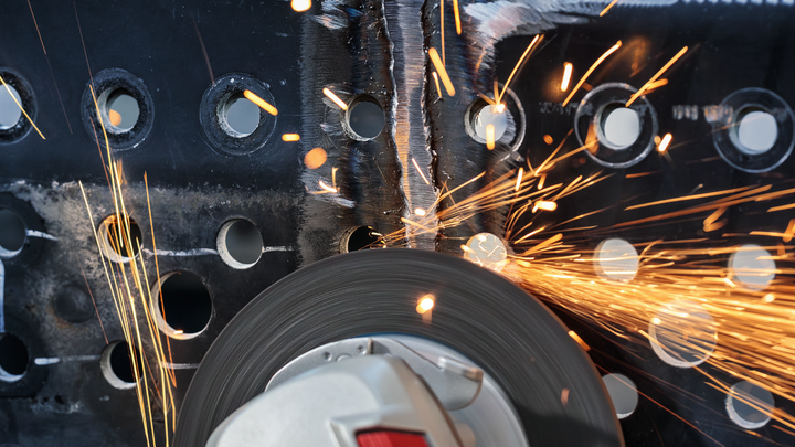 Angle grinder cutting through metal, producing bright sparks.