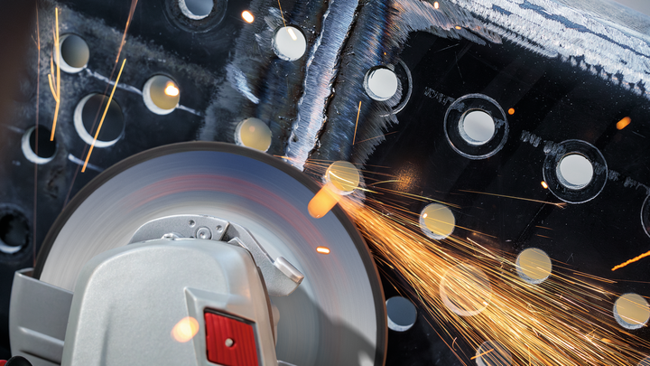 Cutting tool grinding through perforated metal, sparks flying.