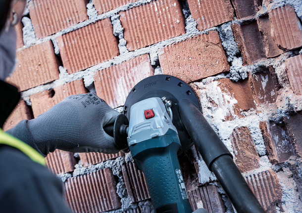 Bosch dust extraction guard used for brick wall grinding.