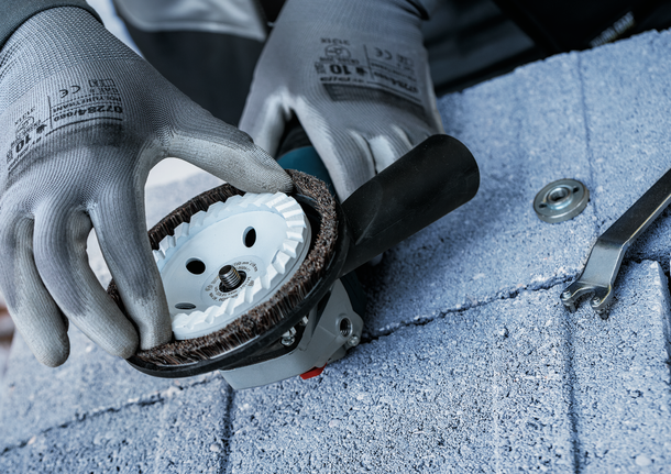 Bosch X-LOCK abrasive brush disc being mounted.