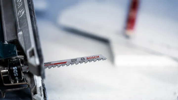 A jigsaw blade installed in a power tool, ready for cutting.