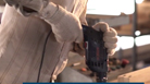 A person in gloves operates a Bosch Professional tool in a workshop environment.