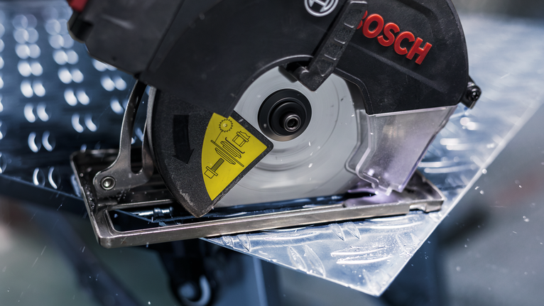 Circular saw cutting through a sheet of metal.