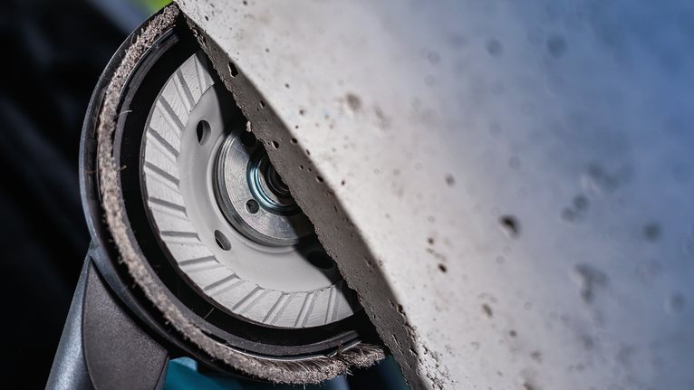 Diamond cutting disc grinding into concrete surface.