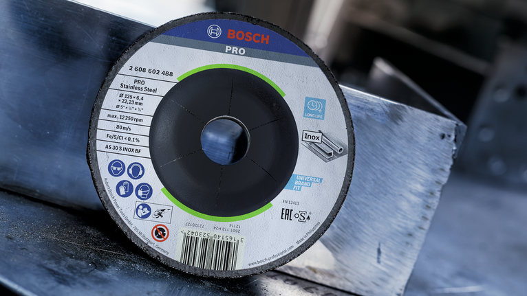 Cutting disc positioned on a metal surface in a workshop.