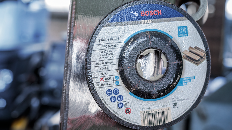 Metal cutting disc mounted on a grinder in a workshop.