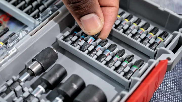 Person selects a screwdriver bit from an organized tool case.