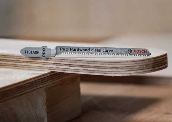 Jigsaw blade placed on a smoothly curved plywood edge.