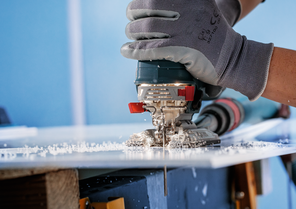 Bosch jigsaw blade cutting through acrylic sheet.