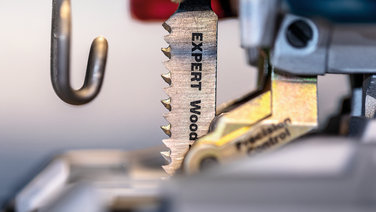 Jigsaw blade labeled for wood cutting clamped into a power tool.