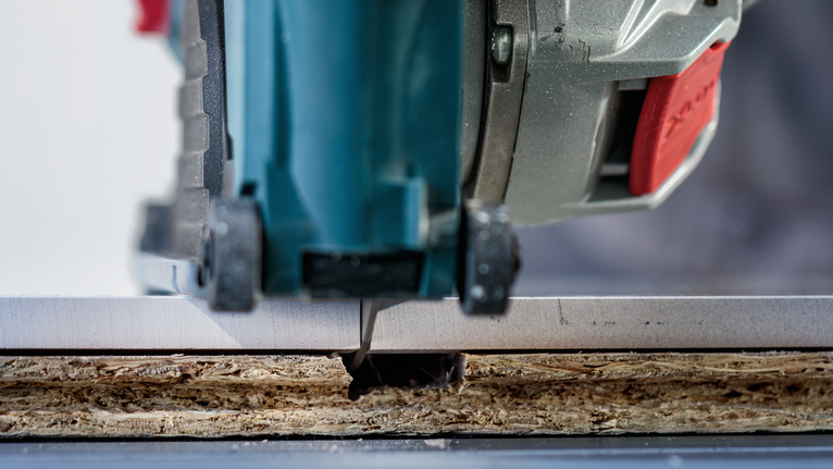 Jigsaw cutting a precise slot in a laminated wooden board.