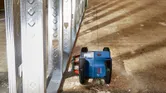 Livella laser che traccia una linea lungo le strutture metalliche di una parete in un cantiere.