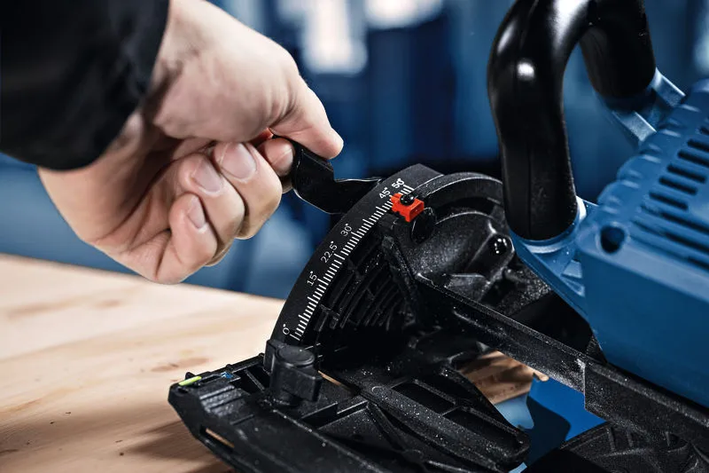 Una persona regola l'impostazione dell'angolazione di una sega circolare a batteria posizionata su una superficie di legno.