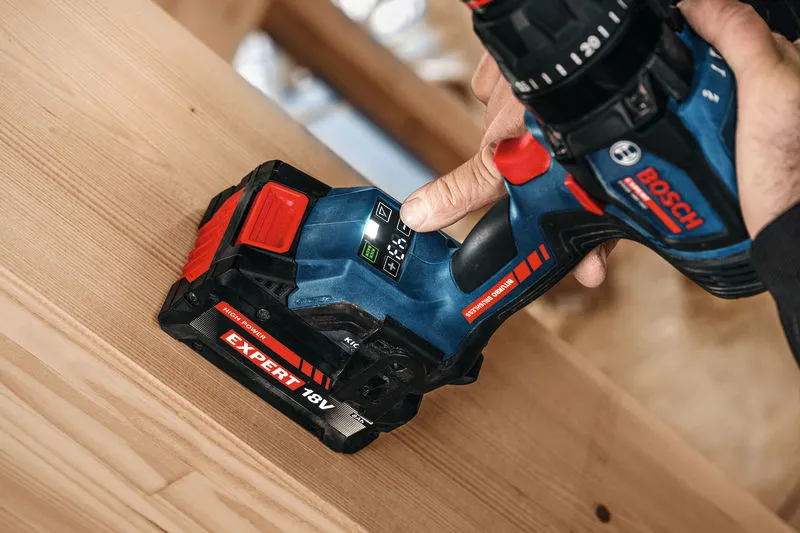 Persona che utilizza un trapano avvitatore a batteria su una tavola di legno.