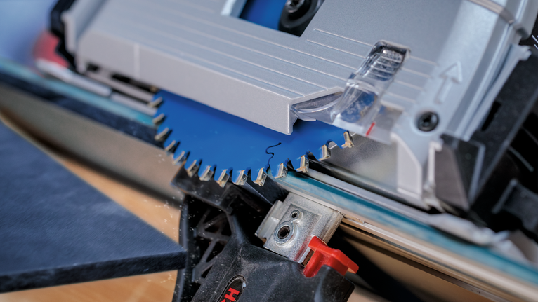 Lama di sega circolare che taglia una tavola di legno.