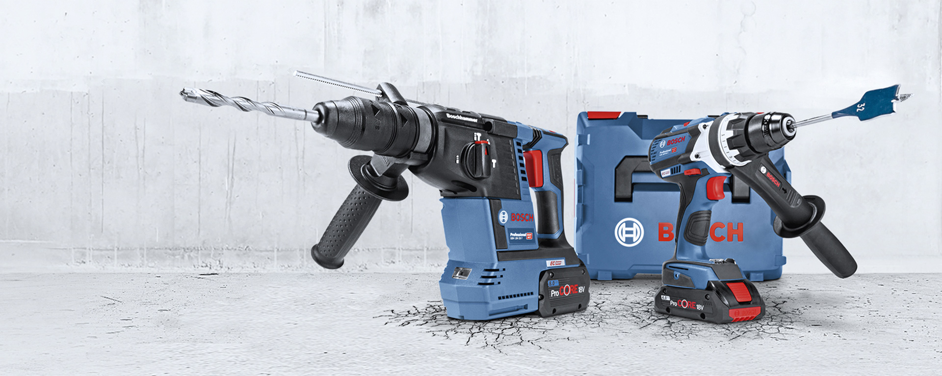 Due strumenti Bosch Professional, un trapano e un avvitatore, su un pavimento di cemento grigio.