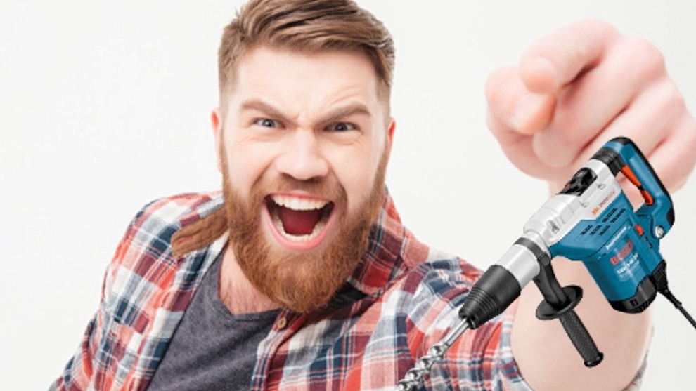 Un uomo con barba tiene un trapano Bosch Professional e sorride entusiasta.