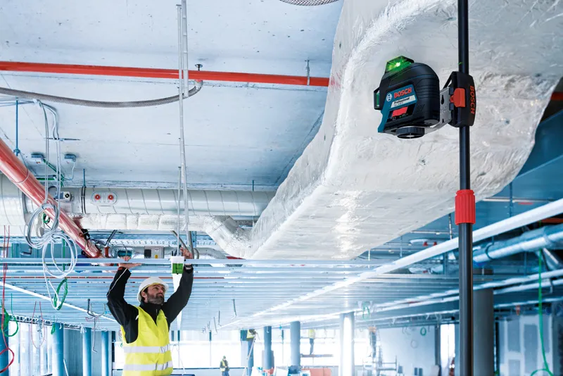 Worker installing ceiling framework.