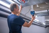A person inspects inside an air duct using an inspection camera.