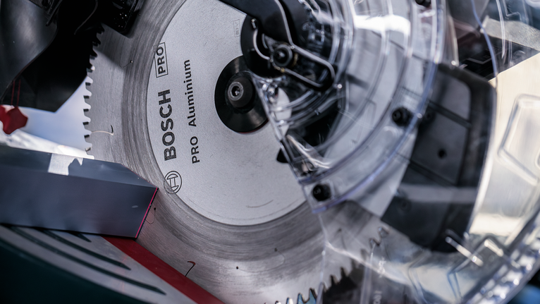 Close-up of a circular saw blade with a transparent blade guard.