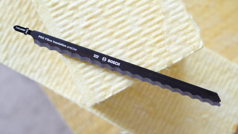 Saw blade resting on stacked insulation boards.