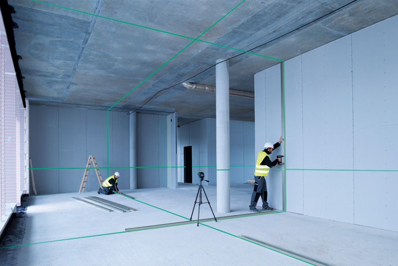 Construction workers using laser level.