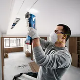 Bosch GOP 185-LI cordless multi-cutter used for ceiling work.