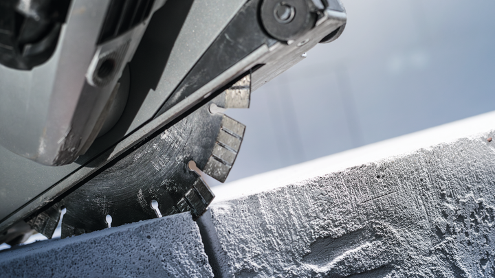 Circular saw blade cutting through a concrete block.