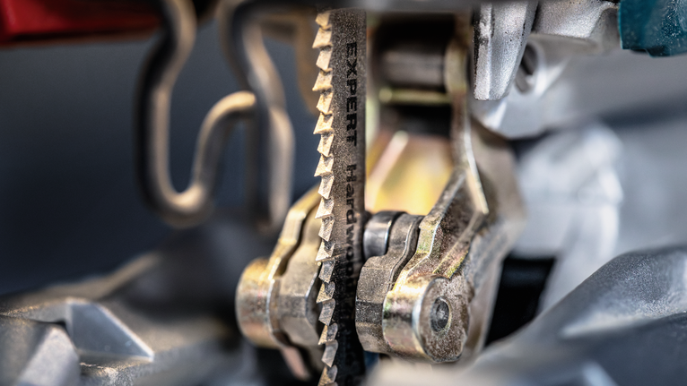 Close-up of a jigsaw blade moving through metal.