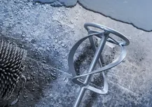 Валик и лопатка для смешивания на мокрой текстурированной бетонной поверхности.