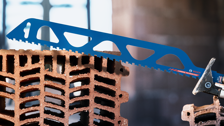 Saw blade cutting through a hollow construction brick.