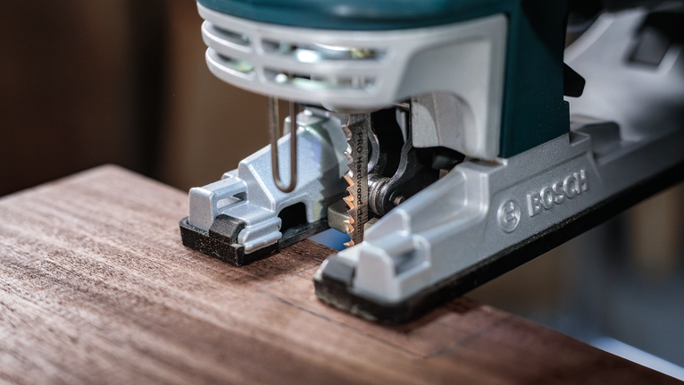 Jigsaw cutting a rectangular shape into a piece of wood.
