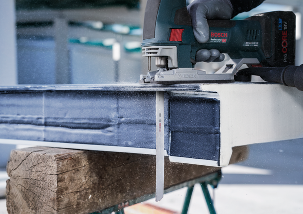 Person wearing safety equipment uses a reciprocating saw to cut through a metal beam.