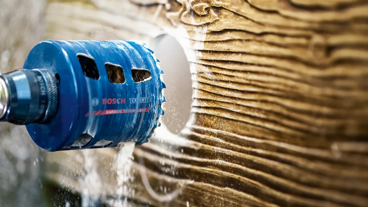 Skylių pjūklo priedas, gręžiantis didelę apvalią skylę mediniame paviršiuje.