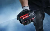 „Bosch Expert 18V“ akumuliatorius laikomas pirštinėtoje rankoje.