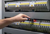 Persona pārbauda elektrisko sadales skapi ar bezkontakta sprieguma testeri.
