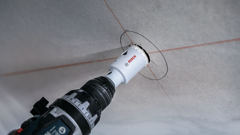 Elektriskais urbis ar caurumzāģa uzgali apaļas atveres griešanai griestos.