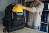 حقيبة ظهر للمقاولين من طراز Bosch L-BOXX تحمل خوذة صلبة صفراء.