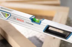 Spirit level resting on wooden beams at a construction site.