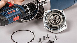 Un taladro inalámbrico Bosch Professional con carcasa desmontada y tornillos.