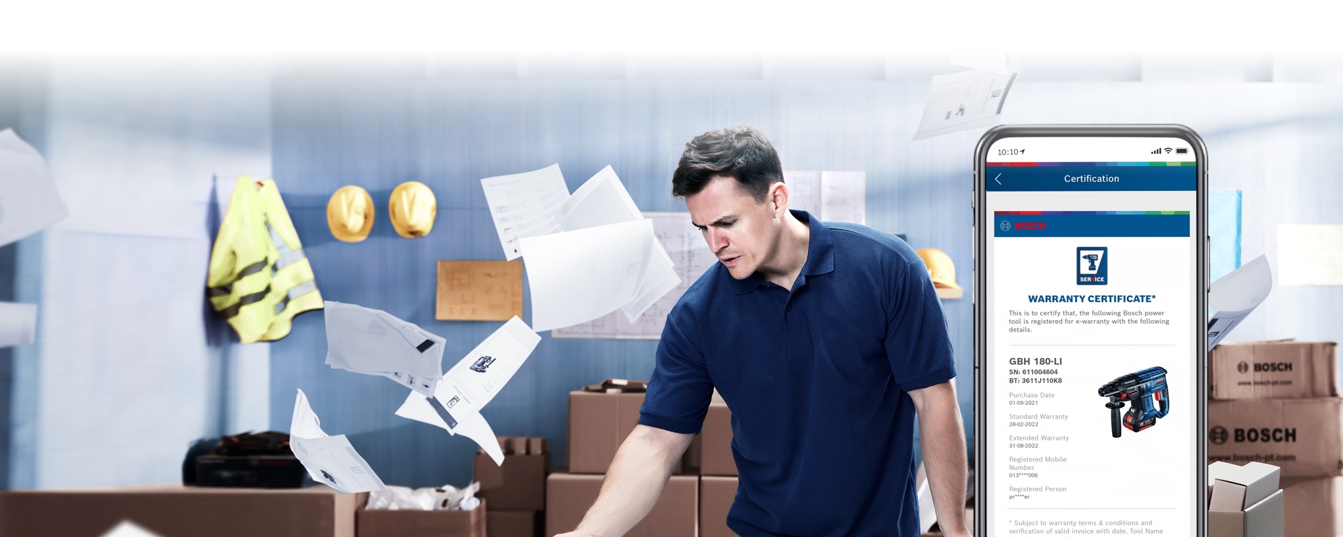A man in a blue polo shirt stands in a warehouse with tools.