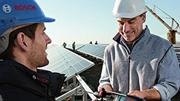 Два чоловіки в шоломах перевіряють інструменти Bosch на сонячній установці.