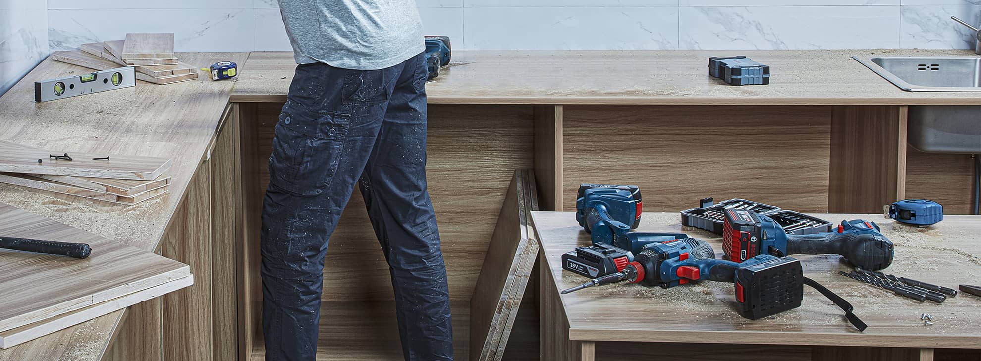 A craftsman works on wood with Bosch Professional tools on a table.