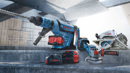 Три инструмента Bosch Professional на бетонной поверхности, синие и красные.