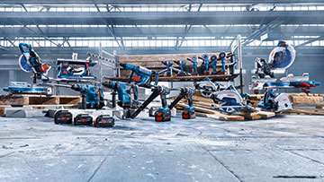 Olika Bosch Professional verktyg och batterier på ett golv.