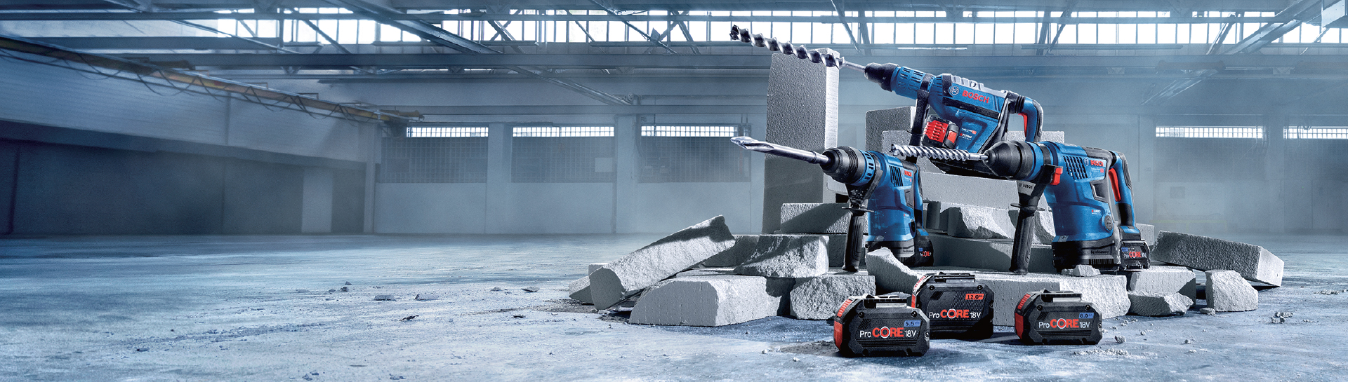 Два синіх інструменти Bosch Professional стоять поруч із сірими бетонними частинами.